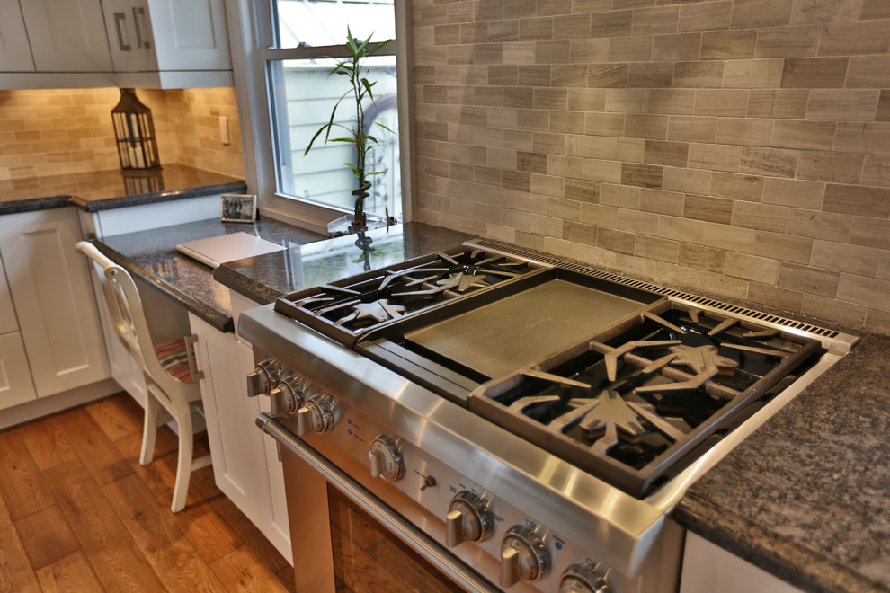 Example of a large minimalist u-shaped medium tone wood floor kitchen design in Toronto with white cabinets, gray backsplash, stainless steel appliances and an island