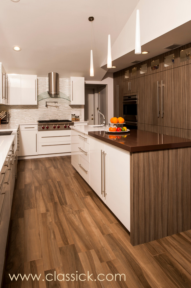 Example of a trendy l-shaped eat-in kitchen design in New York with a farmhouse sink, brown cabinets, quartzite countertops, white backsplash, stainless steel appliances and flat-panel cabinets