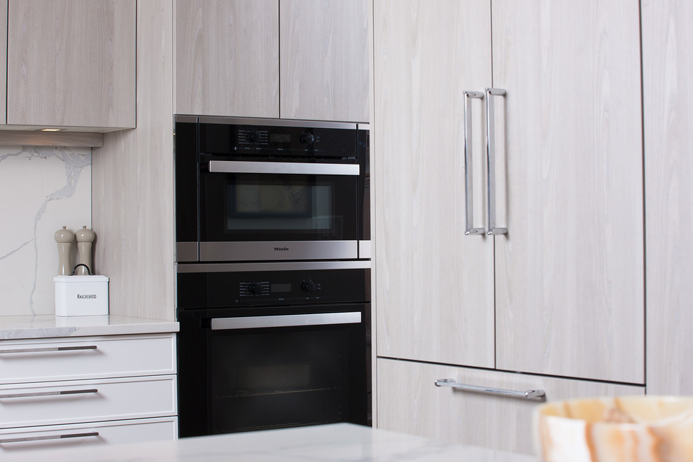 Foto di un cucina con isola centrale moderno con ante lisce, ante grigie, top in marmo, paraspruzzi grigio, paraspruzzi in marmo, elettrodomestici neri e top grigio