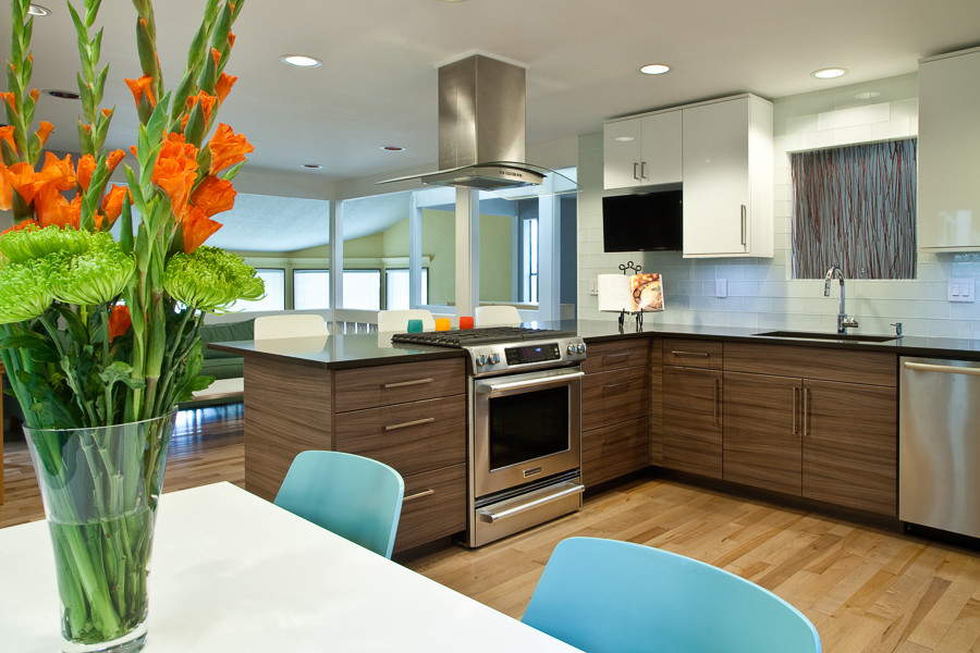 Example of a mid-sized minimalist u-shaped light wood floor eat-in kitchen design in Seattle with an undermount sink, flat-panel cabinets, white cabinets, quartz countertops, white backsplash, glass tile backsplash and stainless steel appliances