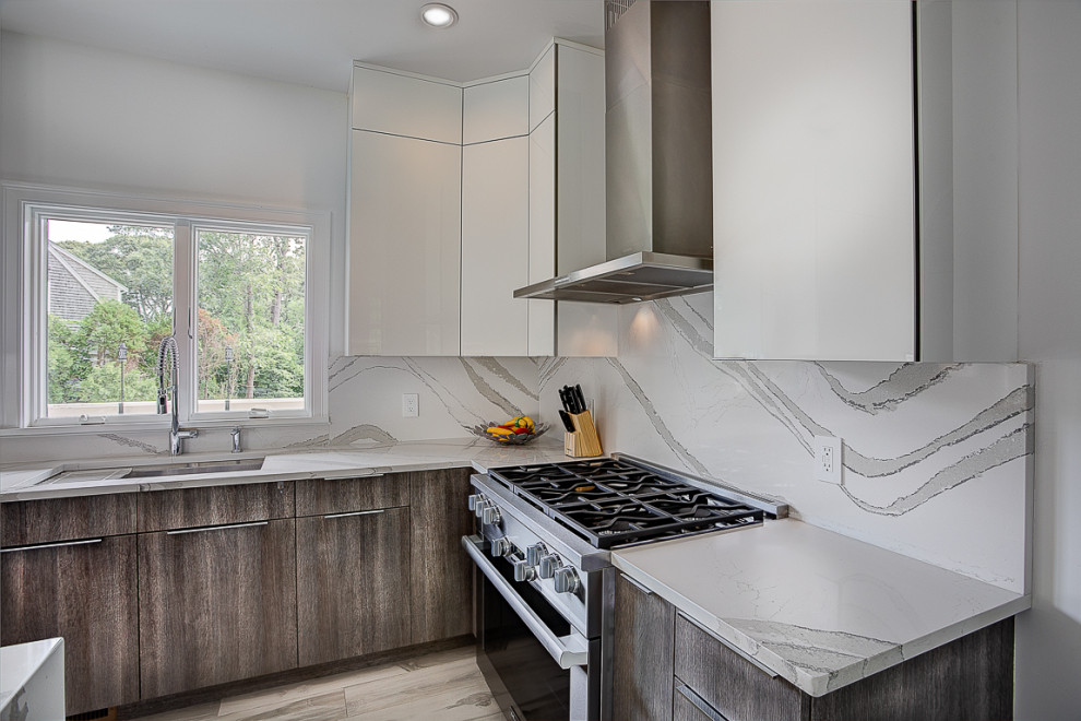 Mid-sized minimalist l-shaped porcelain tile and white floor eat-in kitchen photo in Providence with an undermount sink, flat-panel cabinets, white cabinets, quartz countertops, white backsplash, stone slab backsplash, stainless steel appliances, an island and white countertops