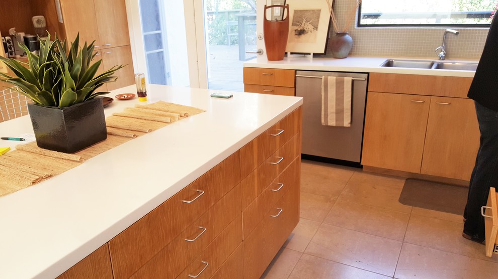 Idée de décoration pour une cuisine minimaliste en L et bois clair fermée et de taille moyenne avec un placard à porte plane et îlot.