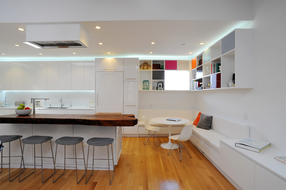 Réalisation d'une cuisine parallèle minimaliste avec un placard à porte plane et des portes de placard blanches.