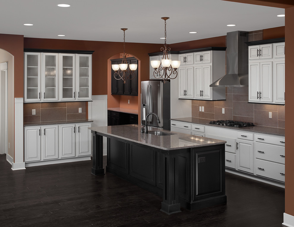 Inspiration for a mid-sized timeless u-shaped dark wood floor and brown floor open concept kitchen remodel in Grand Rapids with a single-bowl sink, raised-panel cabinets, white cabinets, granite countertops, gray backsplash, porcelain backsplash, stainless steel appliances, an island and gray countertops