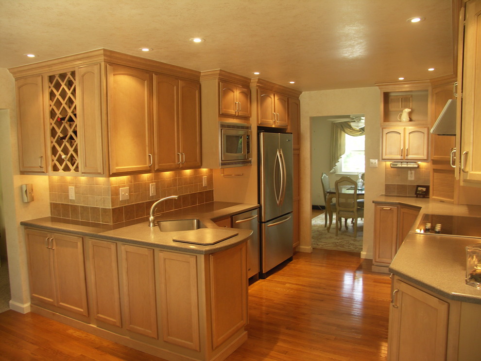 Esempio di una cucina moderna con ante in stile shaker, ante in legno scuro, top in superficie solida, paraspruzzi beige, paraspruzzi in gres porcellanato e elettrodomestici in acciaio inossidabile