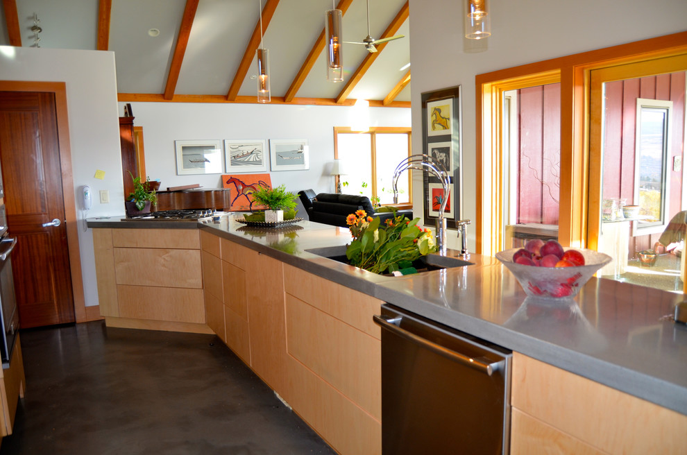 Zweizeilige Moderne Küche mit Halbinsel, flächenbündigen Schrankfronten, hellen Holzschränken, Betonarbeitsplatte, Küchengeräten aus Edelstahl, Unterbauwaschbecken und Betonboden in Vancouver