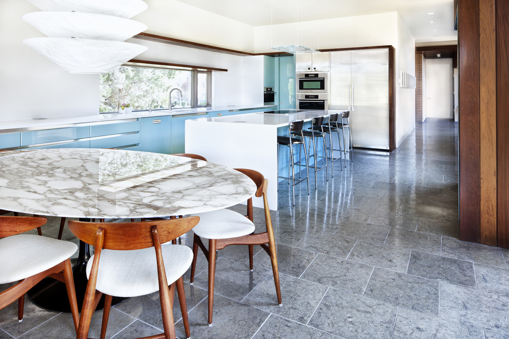 Minimalist eat-in kitchen photo in Austin with stainless steel appliances, flat-panel cabinets, turquoise cabinets and quartz countertops