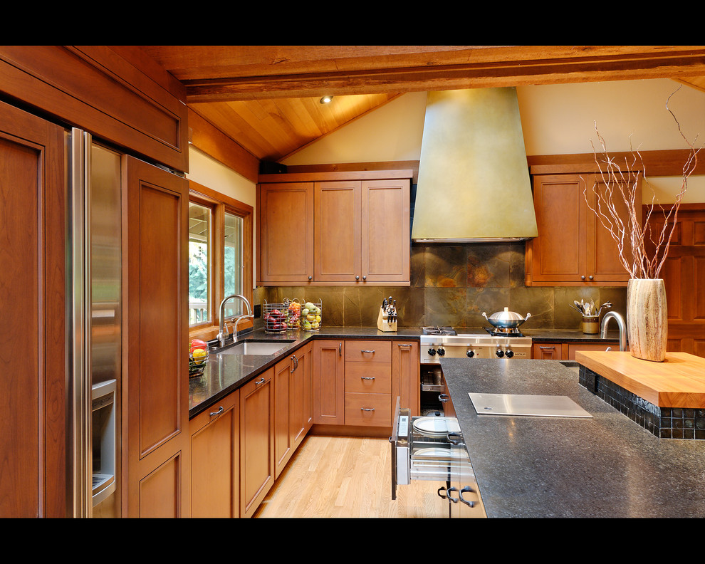 Idéer för att renovera ett funkis kök, med en undermonterad diskho, luckor med infälld panel, skåp i mellenmörkt trä, granitbänkskiva, grått stänkskydd, stänkskydd i stenkakel, rostfria vitvaror, ljust trägolv och en köksö