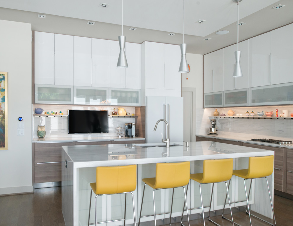 Example of a minimalist l-shaped light wood floor open concept kitchen design in Kansas City with an undermount sink, flat-panel cabinets, white cabinets, marble countertops, white backsplash, white appliances and an island