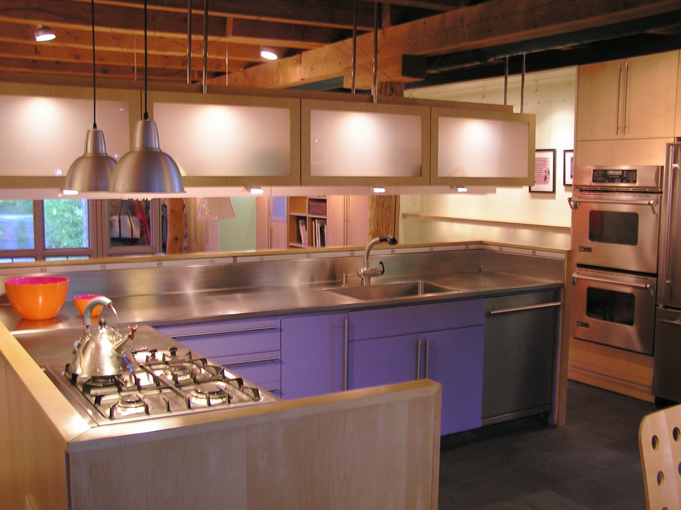 Contemporary kitchen in Boston with glass-front cabinets, stainless steel worktops and stainless steel appliances.