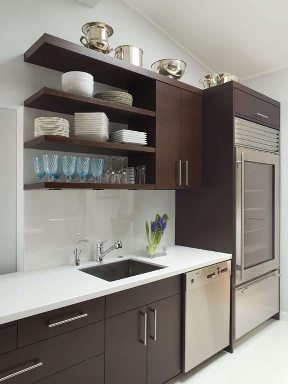 Example of a mid-sized minimalist galley ceramic tile enclosed kitchen design in San Francisco with flat-panel cabinets, dark wood cabinets, quartz countertops, white backsplash, glass sheet backsplash, an undermount sink, stainless steel appliances and no island