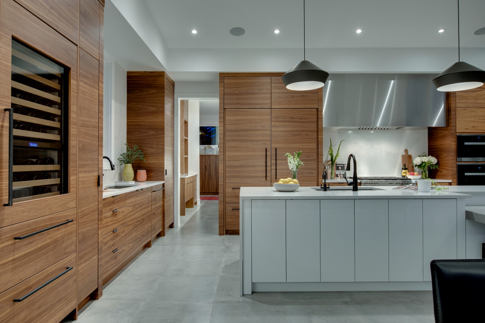 This is an example of a large modern l-shaped kitchen/diner in Calgary with a submerged sink, flat-panel cabinets, medium wood cabinets, engineered stone countertops, white splashback, marble splashback, integrated appliances, ceramic flooring, an island, grey floors and white worktops.