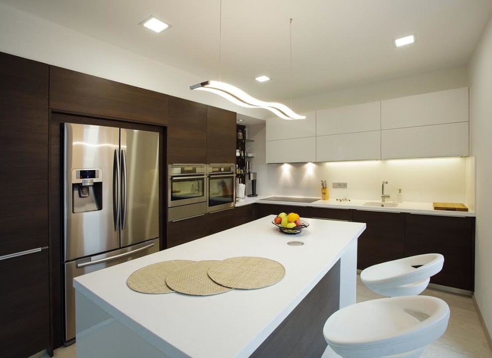 Medium sized modern l-shaped enclosed kitchen in Miami with a submerged sink, flat-panel cabinets, dark wood cabinets, quartz worktops, stainless steel appliances, light hardwood flooring, an island and beige floors.