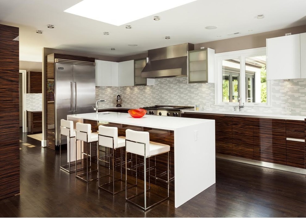 Large modern l-shaped enclosed kitchen in Miami with a submerged sink, flat-panel cabinets, dark wood cabinets, composite countertops, multi-coloured splashback, stainless steel appliances, dark hardwood flooring, an island and brown floors.