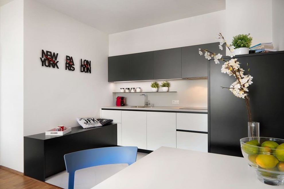 Small modern single-wall kitchen/diner in Miami with a submerged sink, flat-panel cabinets, black cabinets, porcelain flooring, no island and white floors.