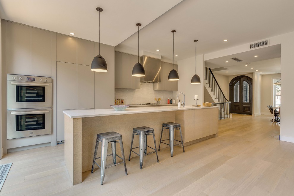 Esempio di una cucina moderna con ante lisce, ante grigie, elettrodomestici in acciaio inossidabile, parquet chiaro, pavimento beige e top bianco