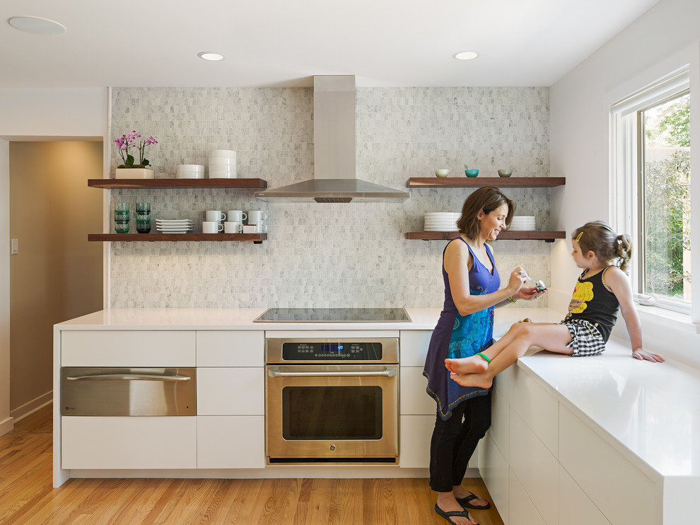 Kitchen - contemporary l-shaped medium tone wood floor kitchen idea in Philadelphia with flat-panel cabinets, white cabinets, multicolored backsplash, stainless steel appliances and no island
