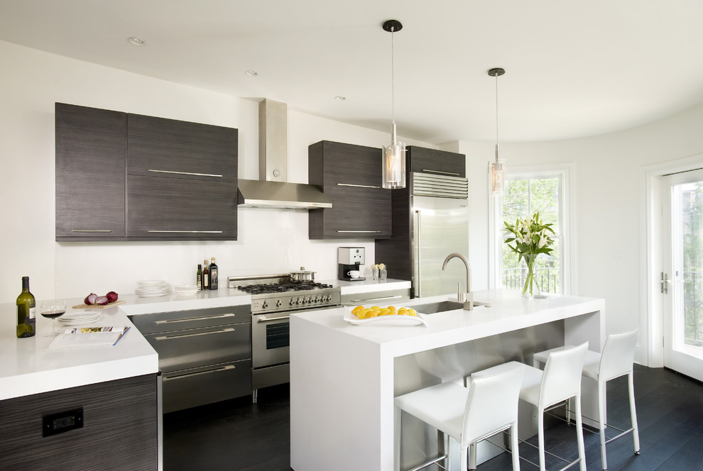 Zweizeilige Moderne Küche mit Küchengeräten aus Edelstahl, Waschbecken, flächenbündigen Schrankfronten, dunklen Holzschränken, Quarzwerkstein-Arbeitsplatte und Glasrückwand in Boston