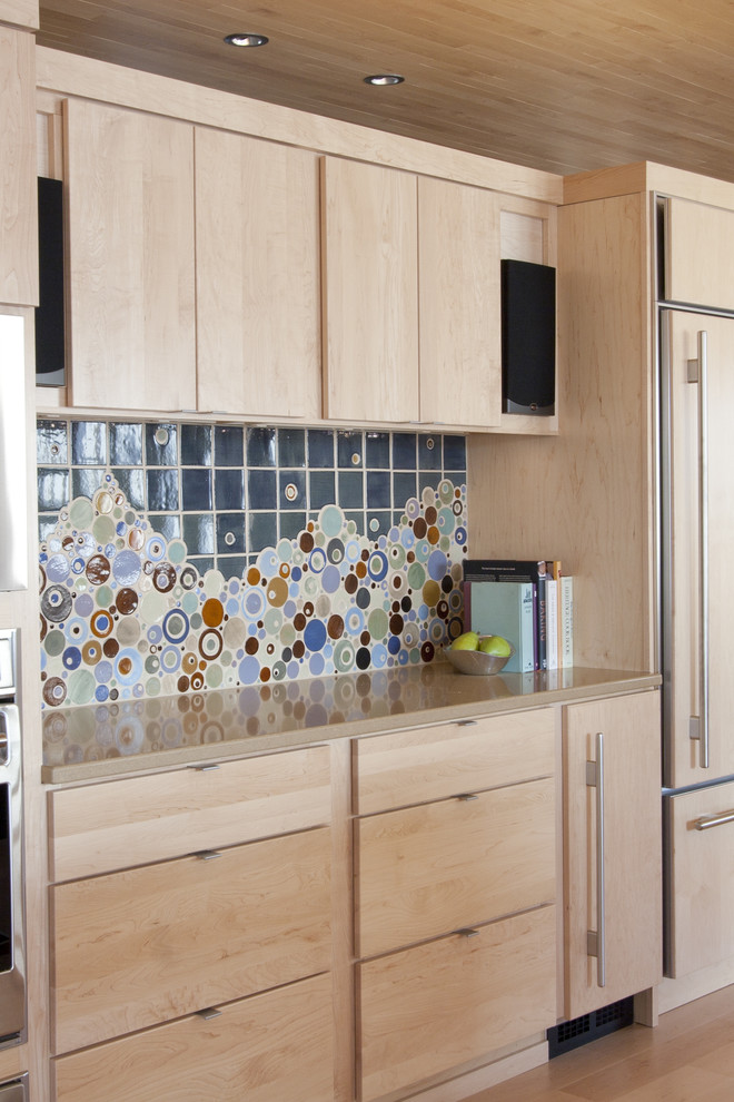 Inspiration för mycket stora moderna kök, med stänkskydd i mosaik, flerfärgad stänkskydd, släta luckor, skåp i ljust trä, rostfria vitvaror, en undermonterad diskho, ljust trägolv, en köksö och bänkskiva i kvarts