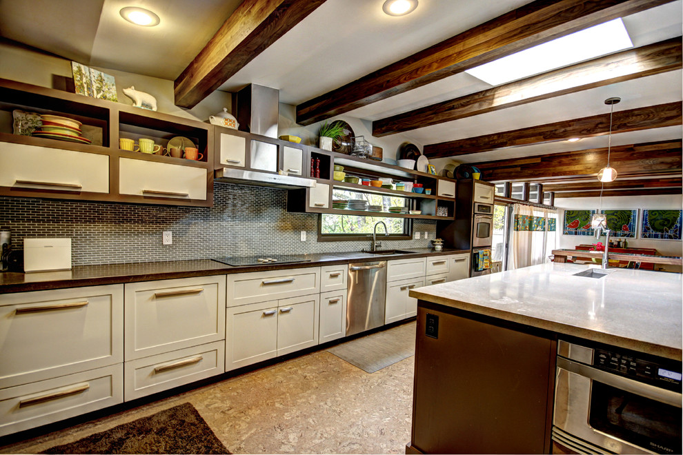 Bild på ett retro kök, med bänkskiva i betong, öppna hyllor, vita skåp, grått stänkskydd och rostfria vitvaror