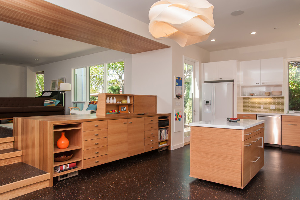 Inspiration pour une cuisine ouverte minimaliste en bois clair avec un placard à porte plane.