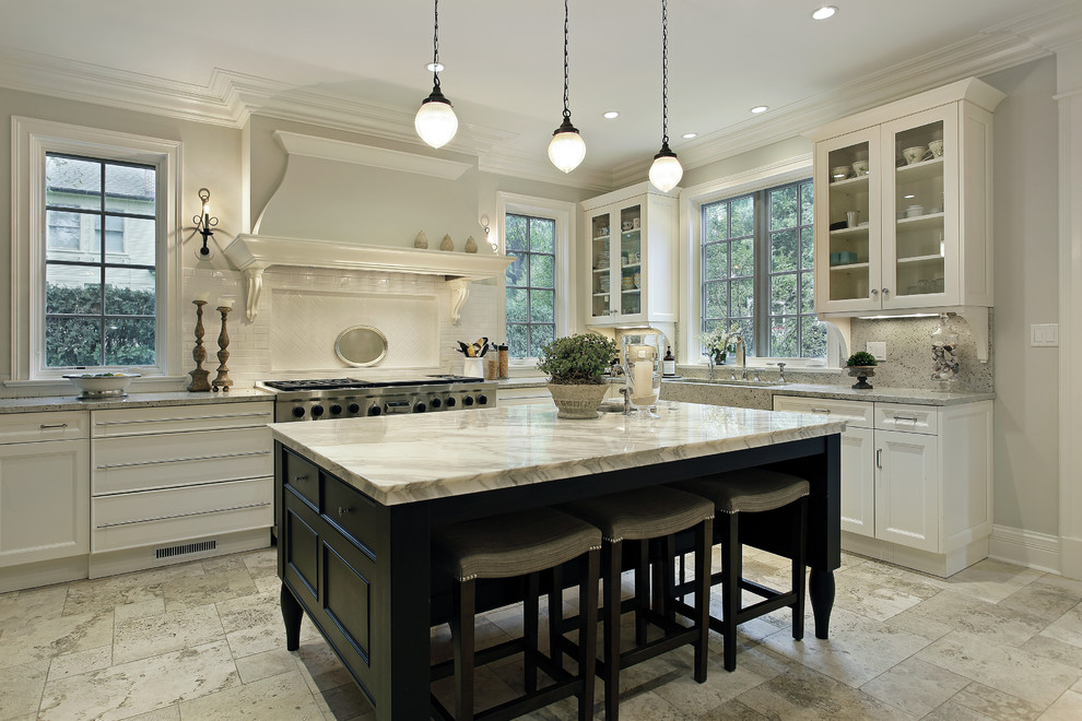 Example of a large minimalist u-shaped limestone floor open concept kitchen design in Atlanta with a farmhouse sink, shaker cabinets, white cabinets, marble countertops, white backsplash, subway tile backsplash, stainless steel appliances and an island