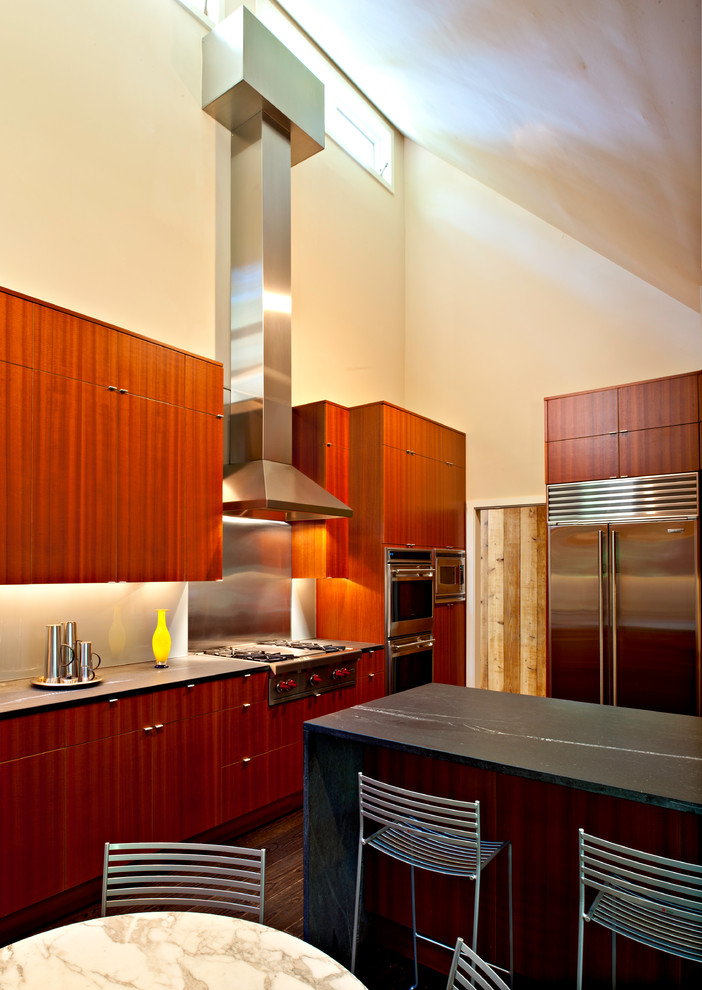 Idéer för ett stort modernt kök, med släta luckor, skåp i mellenmörkt trä, bänkskiva i täljsten, stänkskydd med metallisk yta, stänkskydd i metallkakel, rostfria vitvaror, mörkt trägolv och en halv köksö