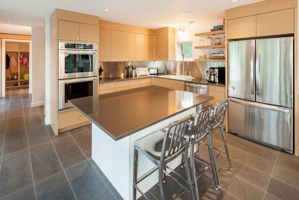 Modern kitchen in Vancouver with flat-panel cabinets, light wood cabinets and stainless steel appliances.