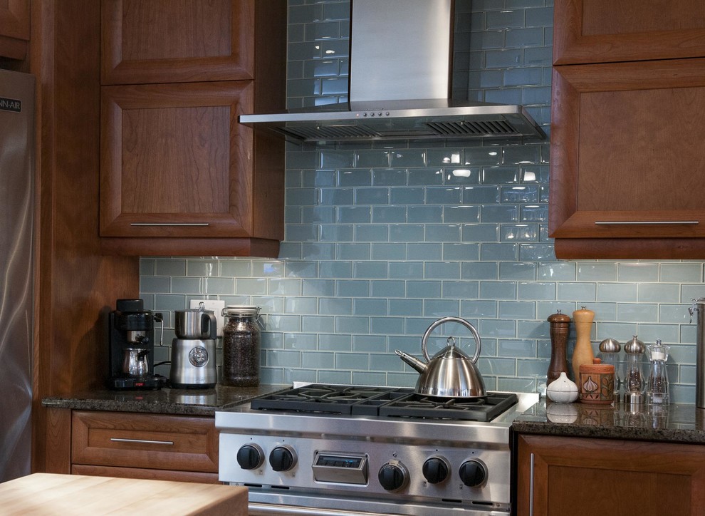 Exempel på ett stort modernt kök, med en undermonterad diskho, luckor med infälld panel, skåp i mellenmörkt trä, bänkskiva i kvartsit, blått stänkskydd, stänkskydd i glaskakel, rostfria vitvaror, klinkergolv i keramik och en halv köksö