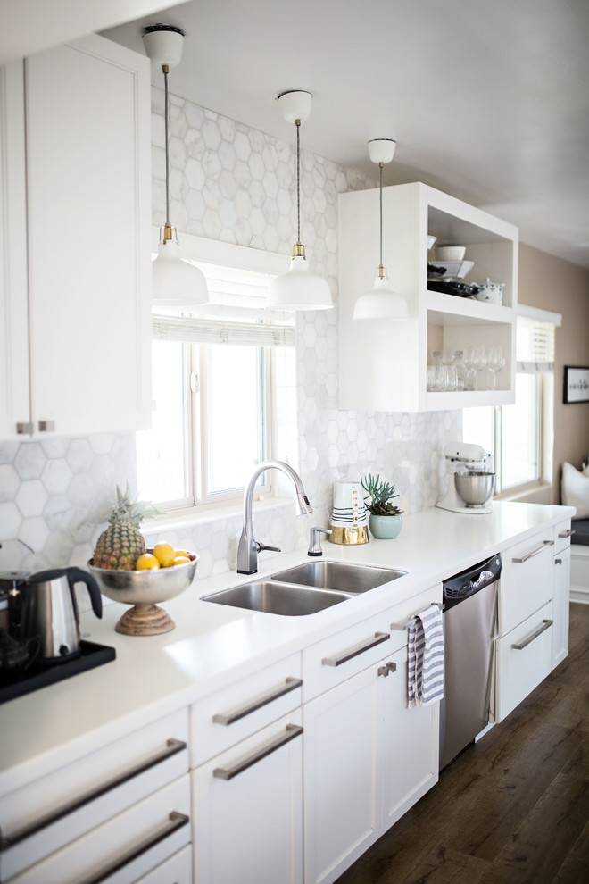 Modern inredning av ett litet vit vitt kök, med en dubbel diskho, öppna hyllor, vita skåp, bänkskiva i kvarts, vitt stänkskydd, stänkskydd i marmor, rostfria vitvaror, laminatgolv och beiget golv
