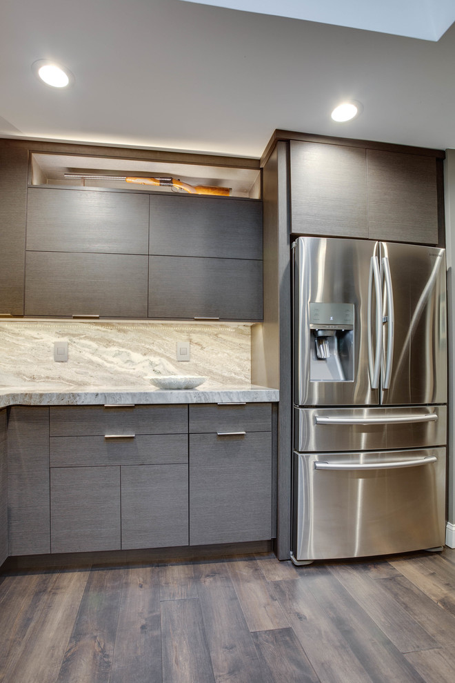 Esempio di una cucina minimalista chiusa e di medie dimensioni con lavello sottopiano, ante lisce, ante grigie, top in granito, elettrodomestici in acciaio inossidabile e penisola