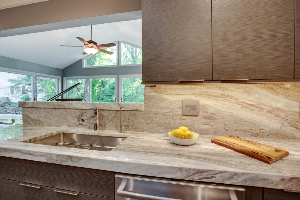 Immagine di una cucina minimalista chiusa e di medie dimensioni con lavello sottopiano, ante lisce, ante grigie, top in granito, elettrodomestici in acciaio inossidabile e penisola