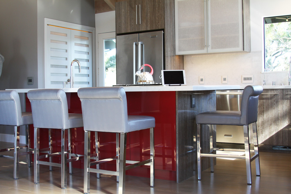 Große Moderne Wohnküche in L-Form mit Unterbauwaschbecken, flächenbündigen Schrankfronten, braunen Schränken, Quarzwerkstein-Arbeitsplatte, Küchengeräten aus Edelstahl, braunem Holzboden, Kücheninsel und braunem Boden in San Luis Obispo