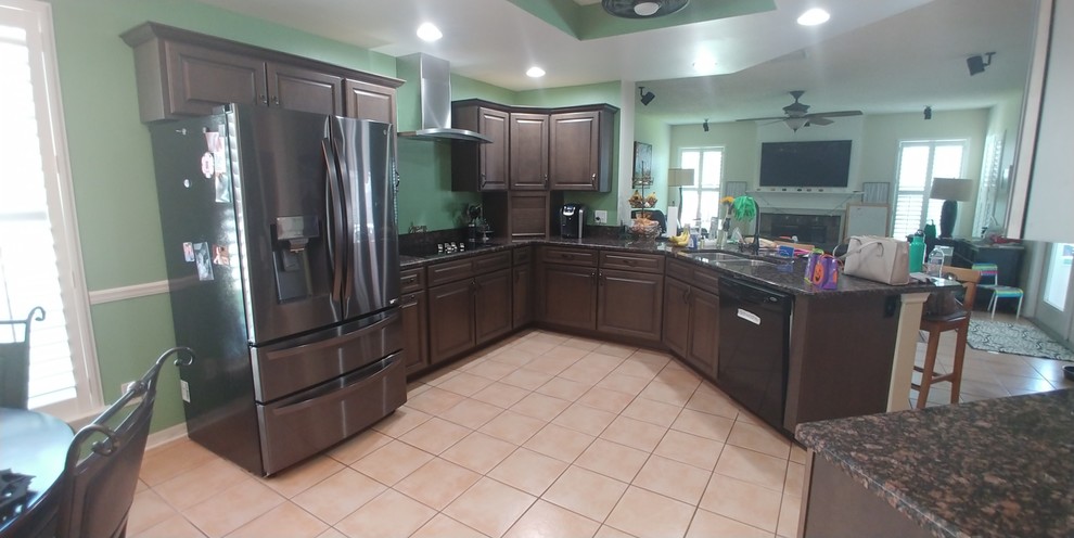 Medium sized modern u-shaped kitchen/diner in Tampa with raised-panel cabinets and dark wood cabinets.