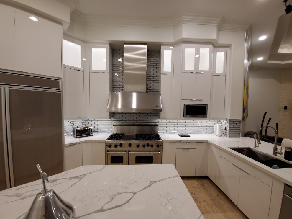Imagen de cocina moderna grande con puertas de armario blancas, encimera de cuarzo compacto y una isla