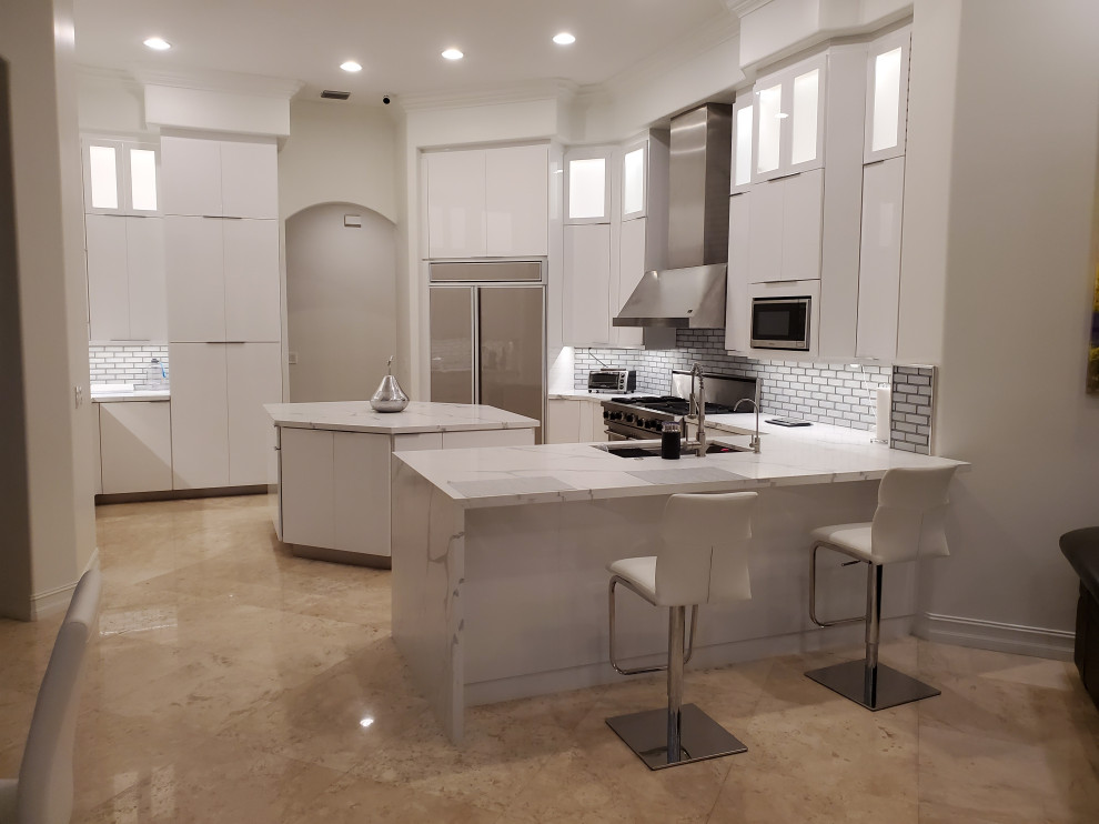 Photo of a large modern u-shaped kitchen/diner in Miami with white cabinets, engineered stone countertops and an island.