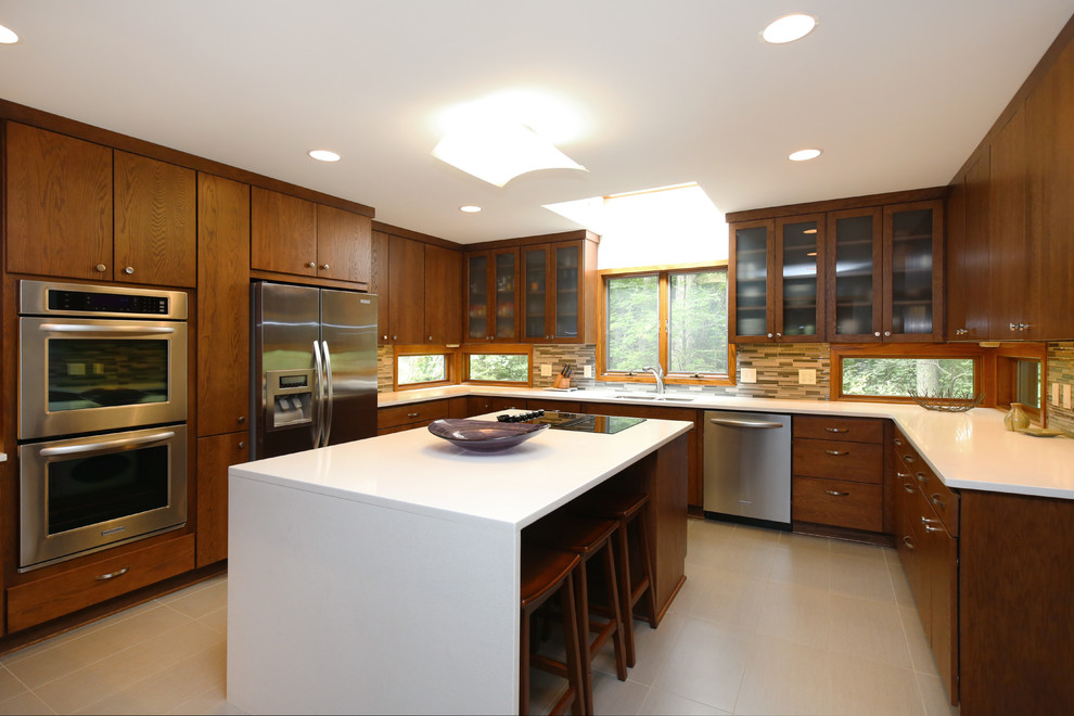 Inredning av ett modernt mellanstort kök, med en dubbel diskho, släta luckor, skåp i mellenmörkt trä, bänkskiva i kvarts, stänkskydd i keramik, rostfria vitvaror, klinkergolv i keramik, en köksö och grått stänkskydd
