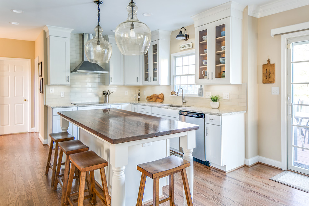 Geschlossene Moderne Küche in L-Form mit Schrankfronten mit vertiefter Füllung, weißen Schränken, Küchenrückwand in Weiß, Küchengeräten aus Edelstahl, hellem Holzboden und Kücheninsel in Baltimore