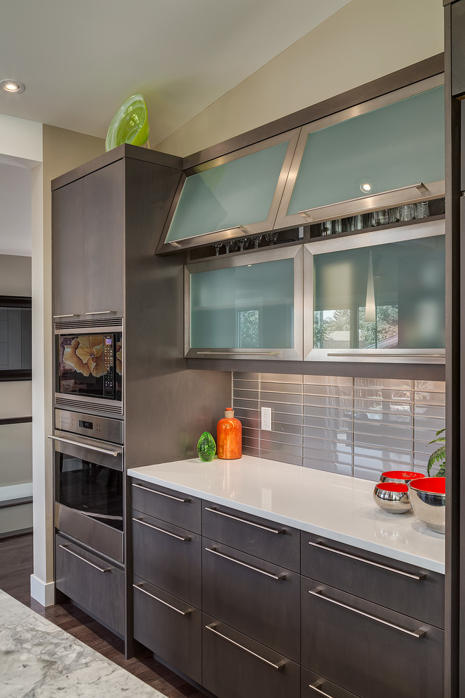 Immagine di una cucina design con ante lisce, ante grigie e paraspruzzi grigio