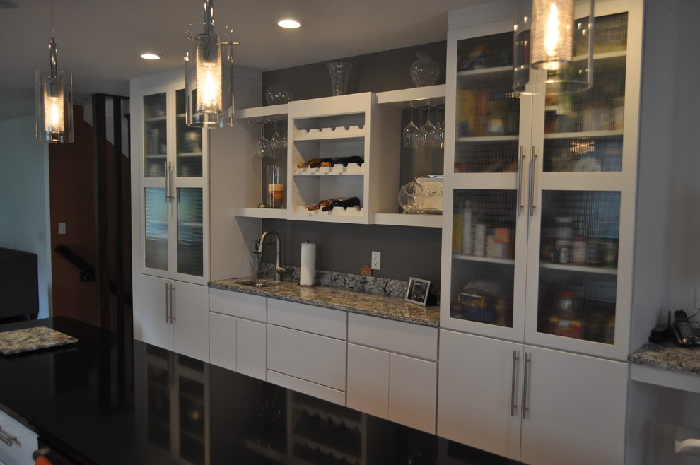 Foto di una grande cucina minimalista chiusa con lavello sottopiano, ante lisce, ante bianche, top in granito, paraspruzzi grigio, paraspruzzi con piastrelle di vetro e elettrodomestici in acciaio inossidabile
