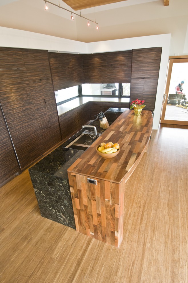 Example of a minimalist l-shaped kitchen design in Albuquerque with flat-panel cabinets and an island