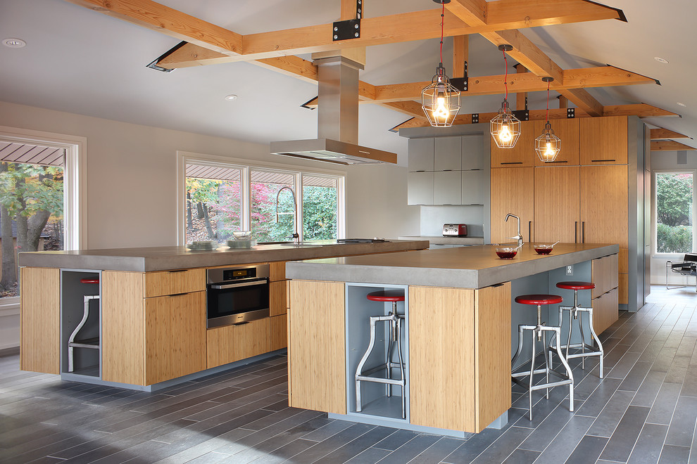 This is an example of a large contemporary kitchen in New York with an integrated sink, flat-panel cabinets, light wood cabinets, concrete worktops, integrated appliances, cement flooring, multiple islands, grey floors and grey worktops.