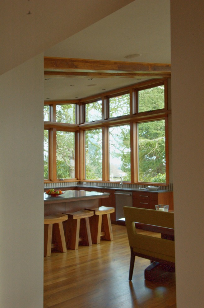 Стильный дизайн: кухня в стиле модернизм с плоскими фасадами, светлыми деревянными фасадами и барной стойкой - последний тренд