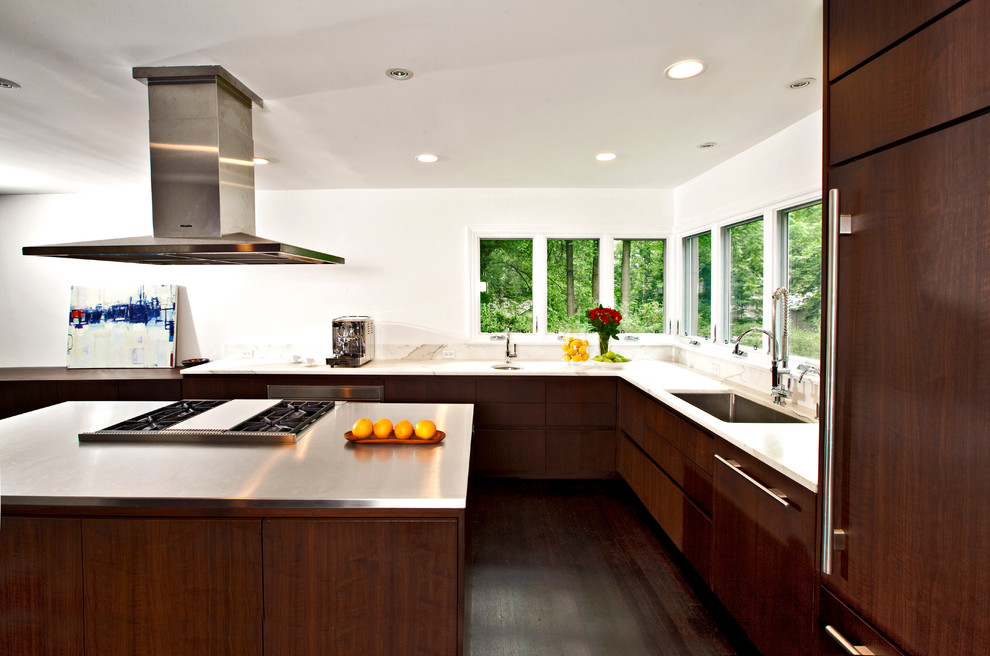 Immagine di una cucina moderna con lavello sottopiano, ante lisce, ante in legno bruno, elettrodomestici da incasso e struttura in muratura