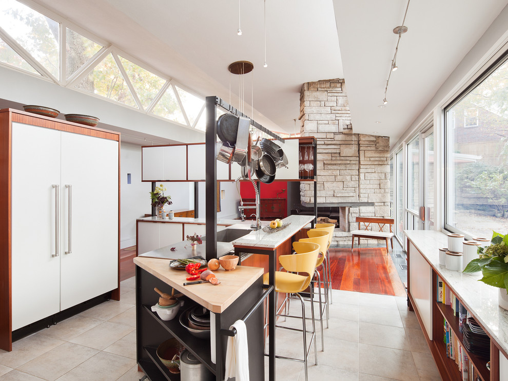 Offene Moderne Küche mit flächenbündigen Schrankfronten, weißen Schränken, Arbeitsplatte aus Holz und Elektrogeräten mit Frontblende in Philadelphia
