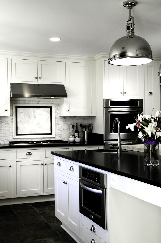 Immagine di una cucina moderna con ante con riquadro incassato, top in granito, paraspruzzi grigio, lavello sottopiano e elettrodomestici in acciaio inossidabile