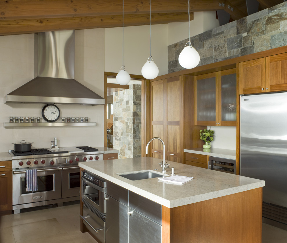 This is an example of a rustic kitchen in San Francisco with glass-front cabinets, stainless steel appliances, a single-bowl sink, medium wood cabinets and a feature wall.