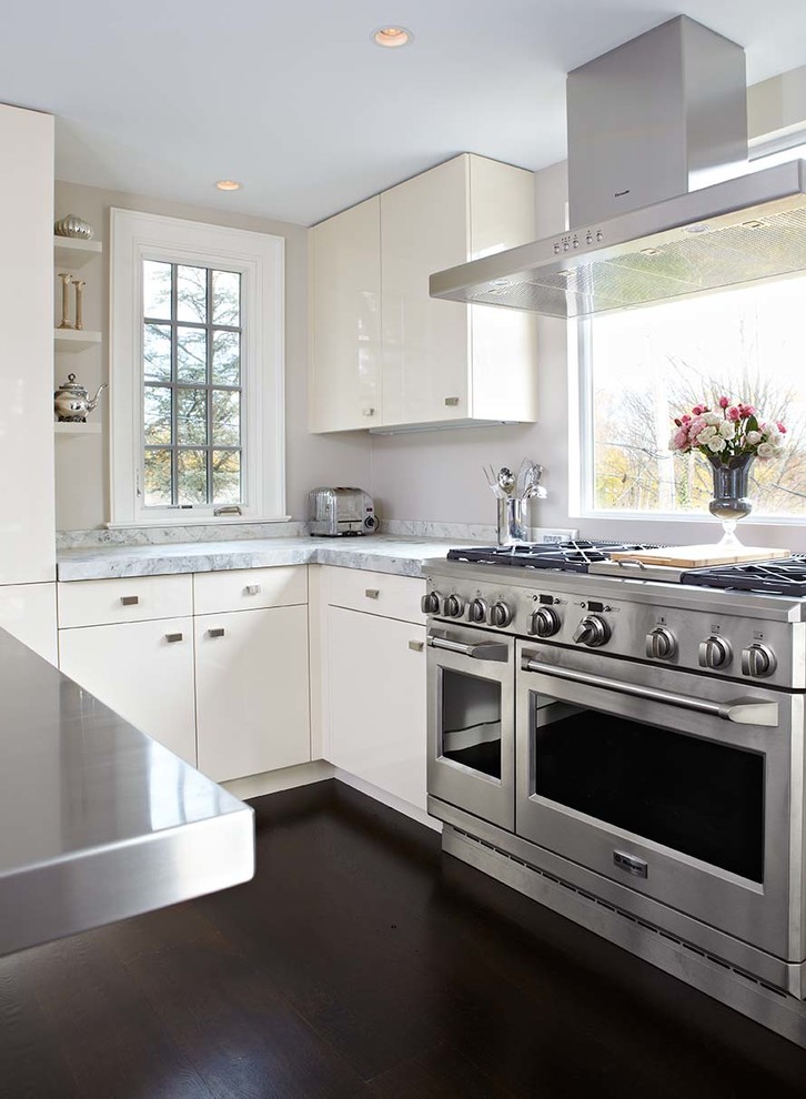 Bild på ett funkis kök, med släta luckor, beige skåp, bänkskiva i rostfritt stål och rostfria vitvaror