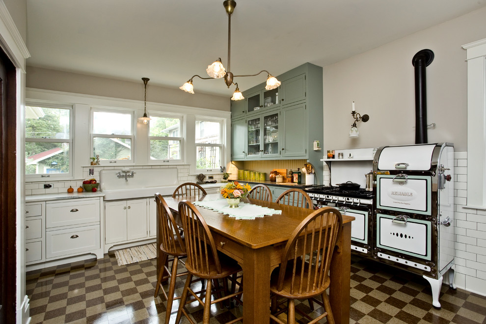 Foto på ett stort vintage kök och matrum, med en rustik diskho, gröna skåp, marmorbänkskiva, vitt stänkskydd, stänkskydd i keramik, vita vitvaror, vinylgolv, brunt golv och skåp i shakerstil
