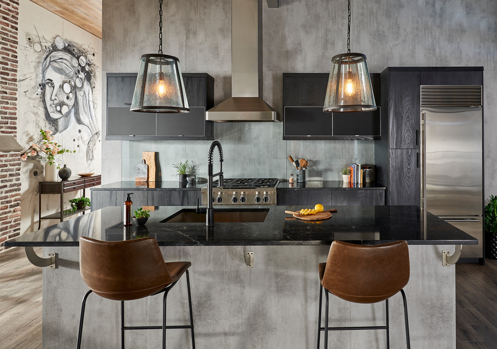 Inspiration for a mid-sized modern single-wall brown floor eat-in kitchen remodel in New York with an undermount sink, flat-panel cabinets, black cabinets, solid surface countertops, gray backsplash, glass sheet backsplash, stainless steel appliances, an island and black countertops
